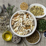 Herbs around bowl of vitamins